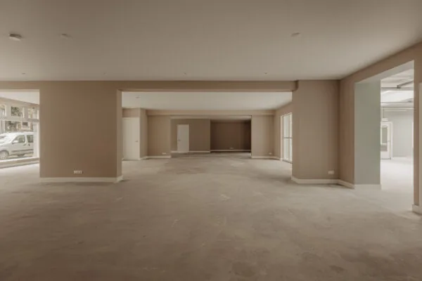 Leegstaand, ruim en licht commercieel pand aan de Henri Polaklaan met grote ramen en betonnen vloer.